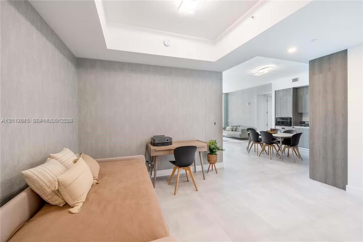 Tray ceiling with recessed lighting, large-format tile flooring, and textured wall finish