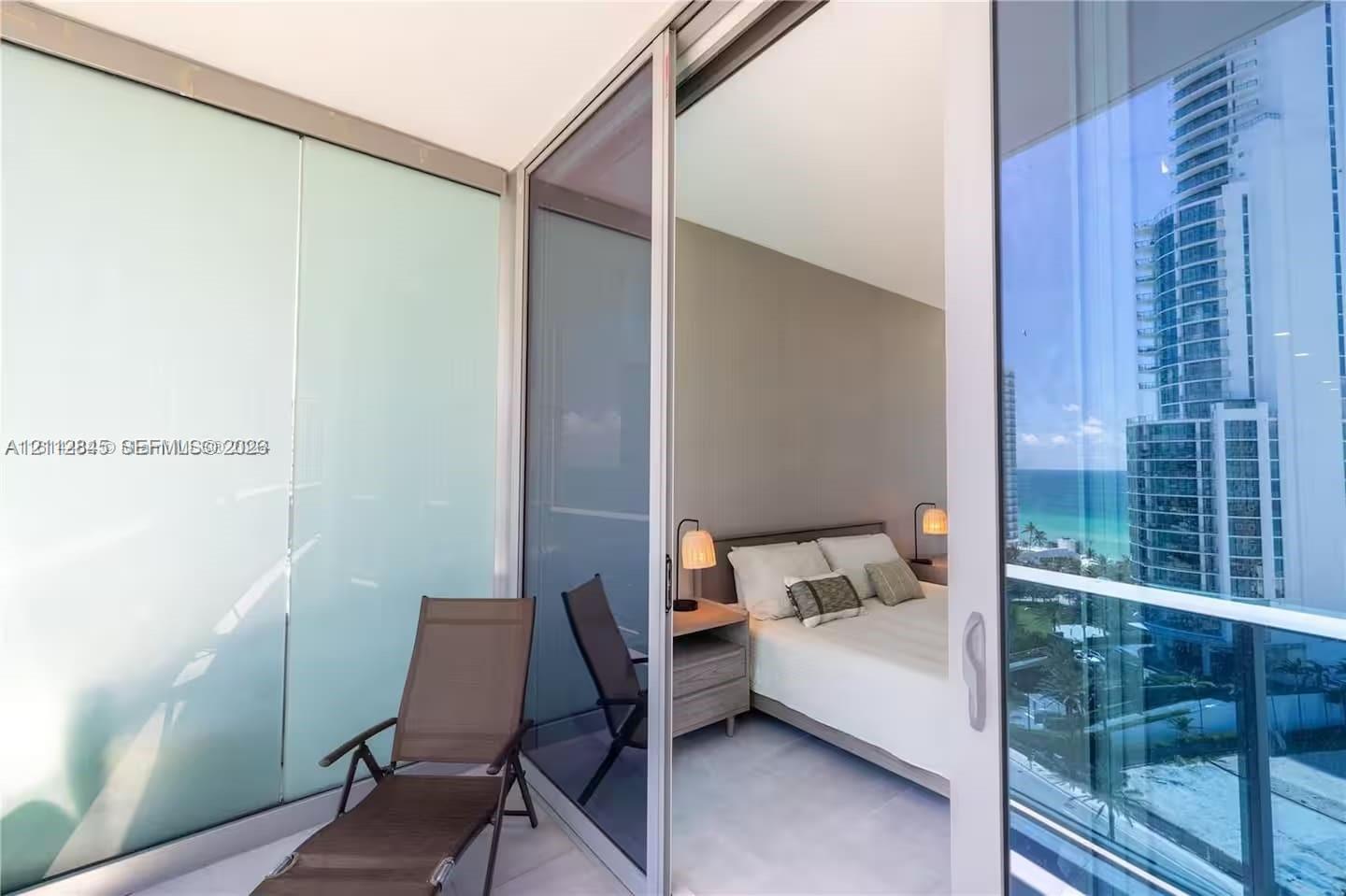 Private balcony featuring floor-to-ceiling glass paneling, tile flooring, and sliding glass door access