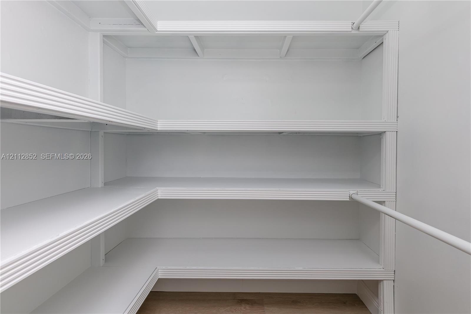Built-in wrap-around shelving with tiered levels and integrated hanging rods