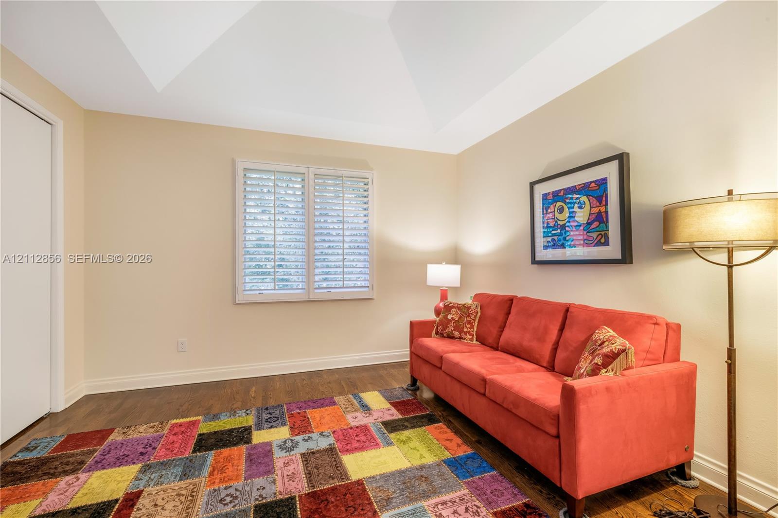 Vaulted ceiling, wood-finish flooring, and window shutters