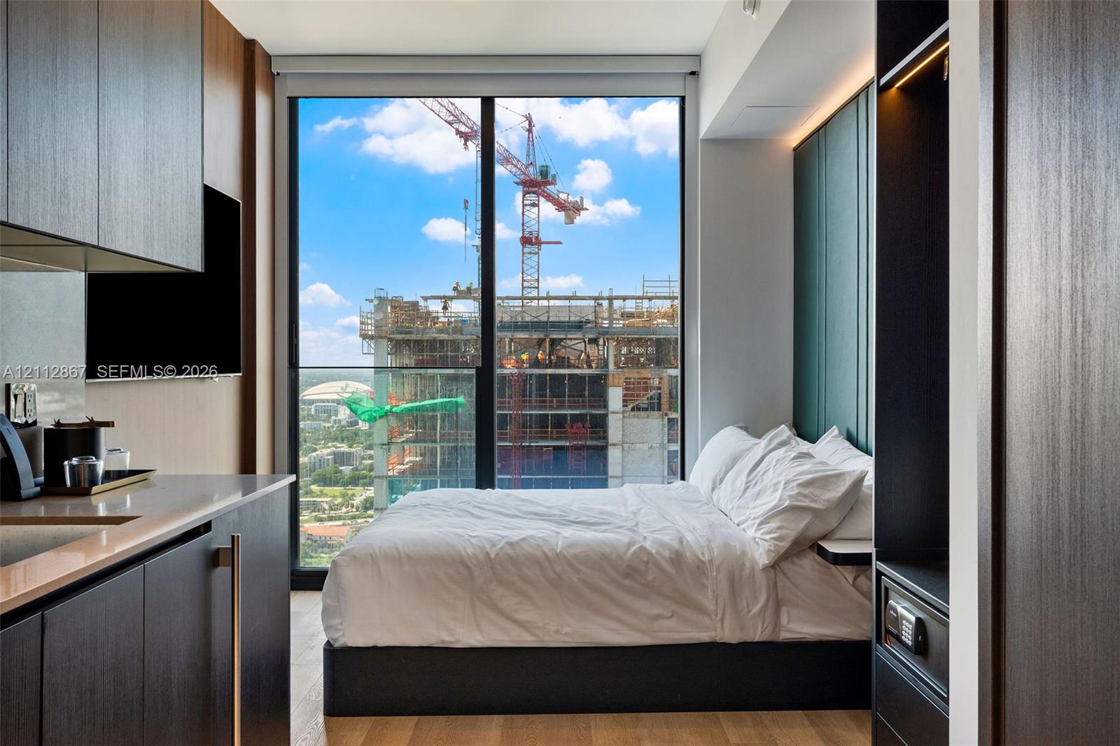 Floor-to-ceiling windows, built-in dark wood-finish cabinetry, wood-finish flooring, and recessed accent lighting Floor-to-ceiling windows, built-in dark wood-finish cabinetry, wood-finish flooring, and recessed accent lighting