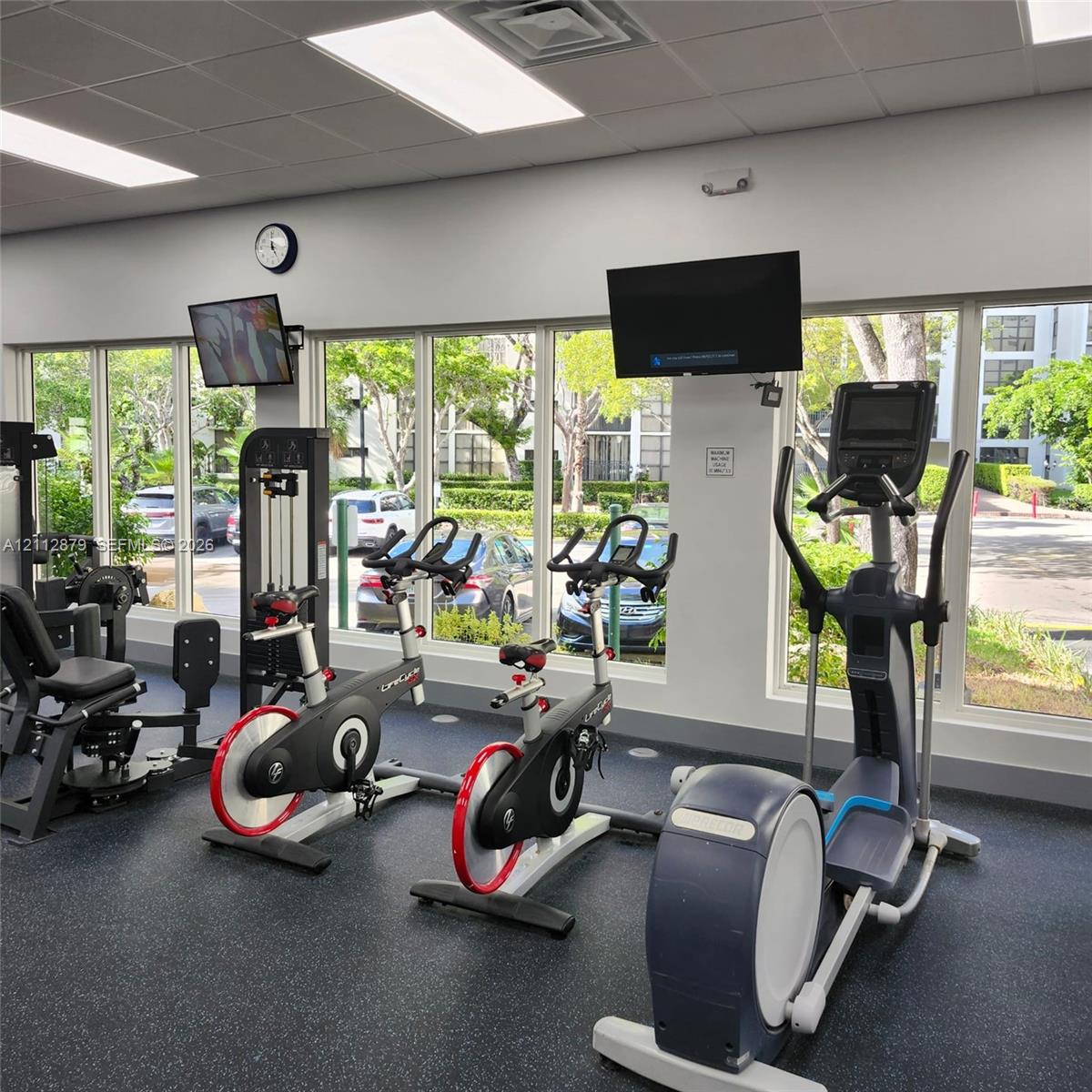 Fitness center featuring floor-to-ceiling windows, rubberized flooring, and recessed ceiling lighting Fitness center featuring floor-to-ceiling windows, rubberized flooring, and recessed ceiling lighting