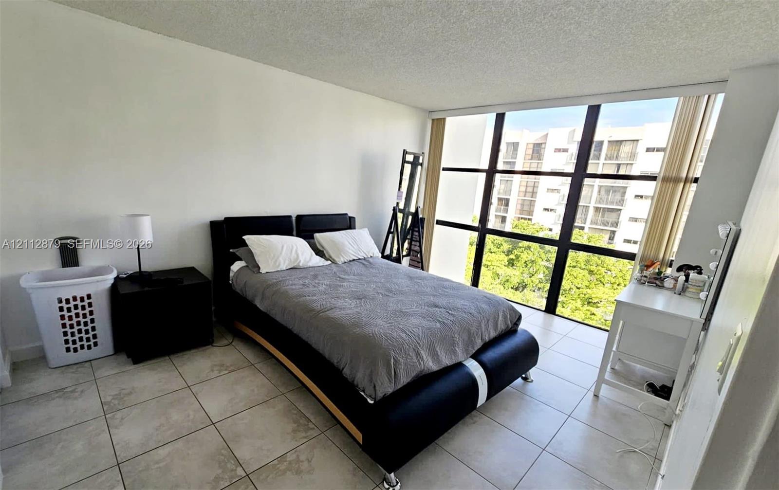 Floor-to-ceiling windows featuring black framing and neutral ceramic tile flooring