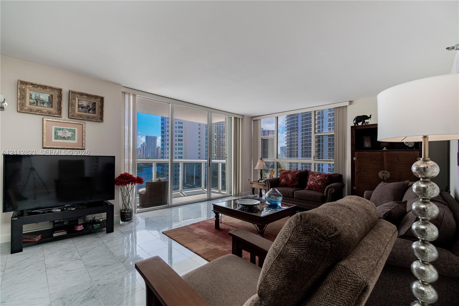 Polished stone flooring, expansive glass sliding doors, and floor-to-ceiling windows
