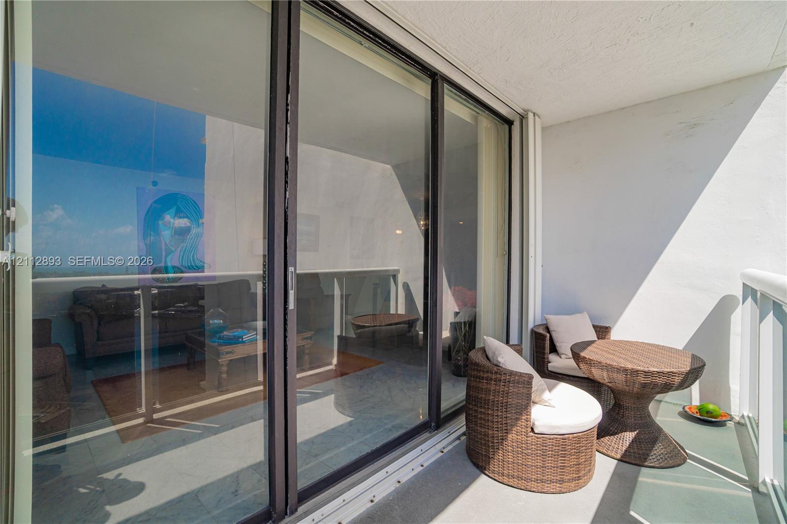 Private balcony featuring sliding glass doors and glass-paneled railings
