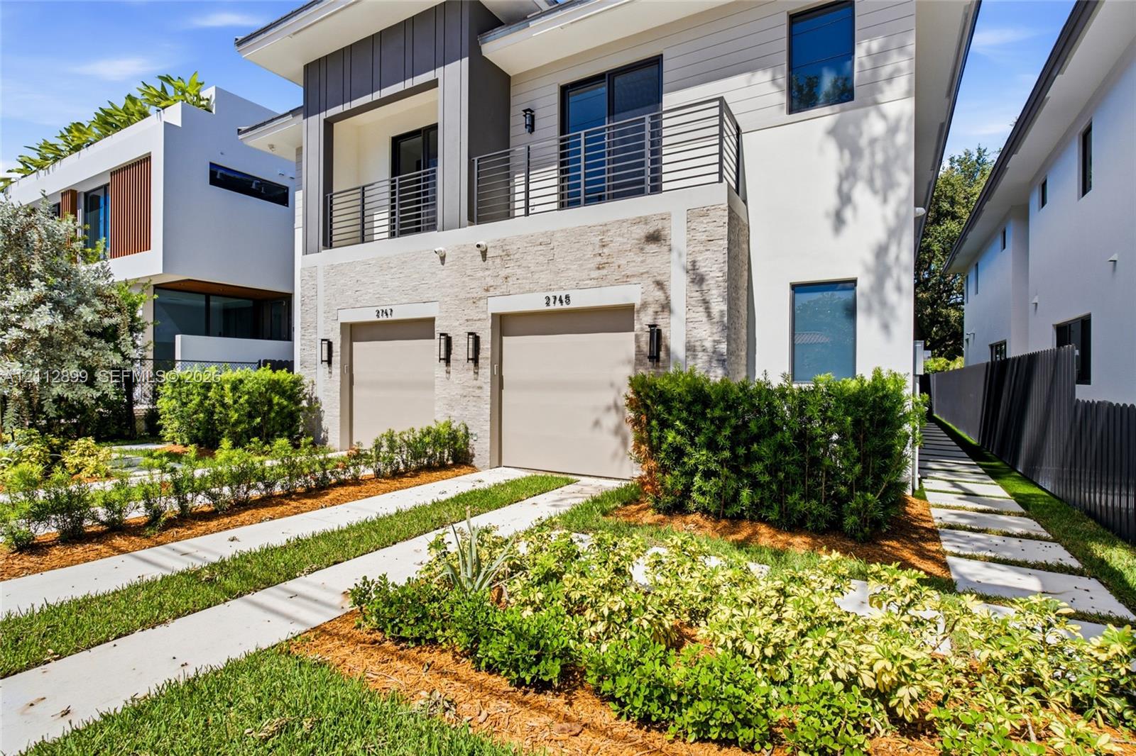Modern two-story architectural exterior featuring smooth stucco, horizontal lap siding, and natural stone veneer accents Modern two-story architectural exterior featuring smooth stucco, horizontal lap siding, and natural stone veneer accents