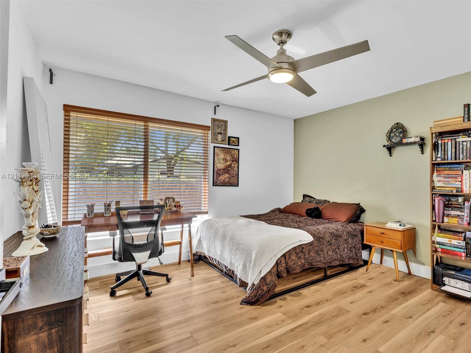 Wood-finish flooring, ceiling fan with integrated lighting, and horizontal window blinds
