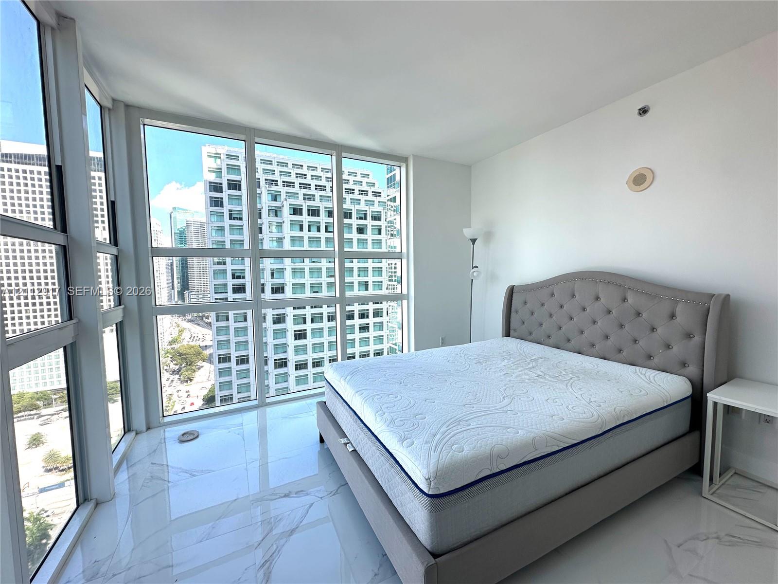 Floor-to-ceiling windows featuring urban scenery and large-format polished tile flooring