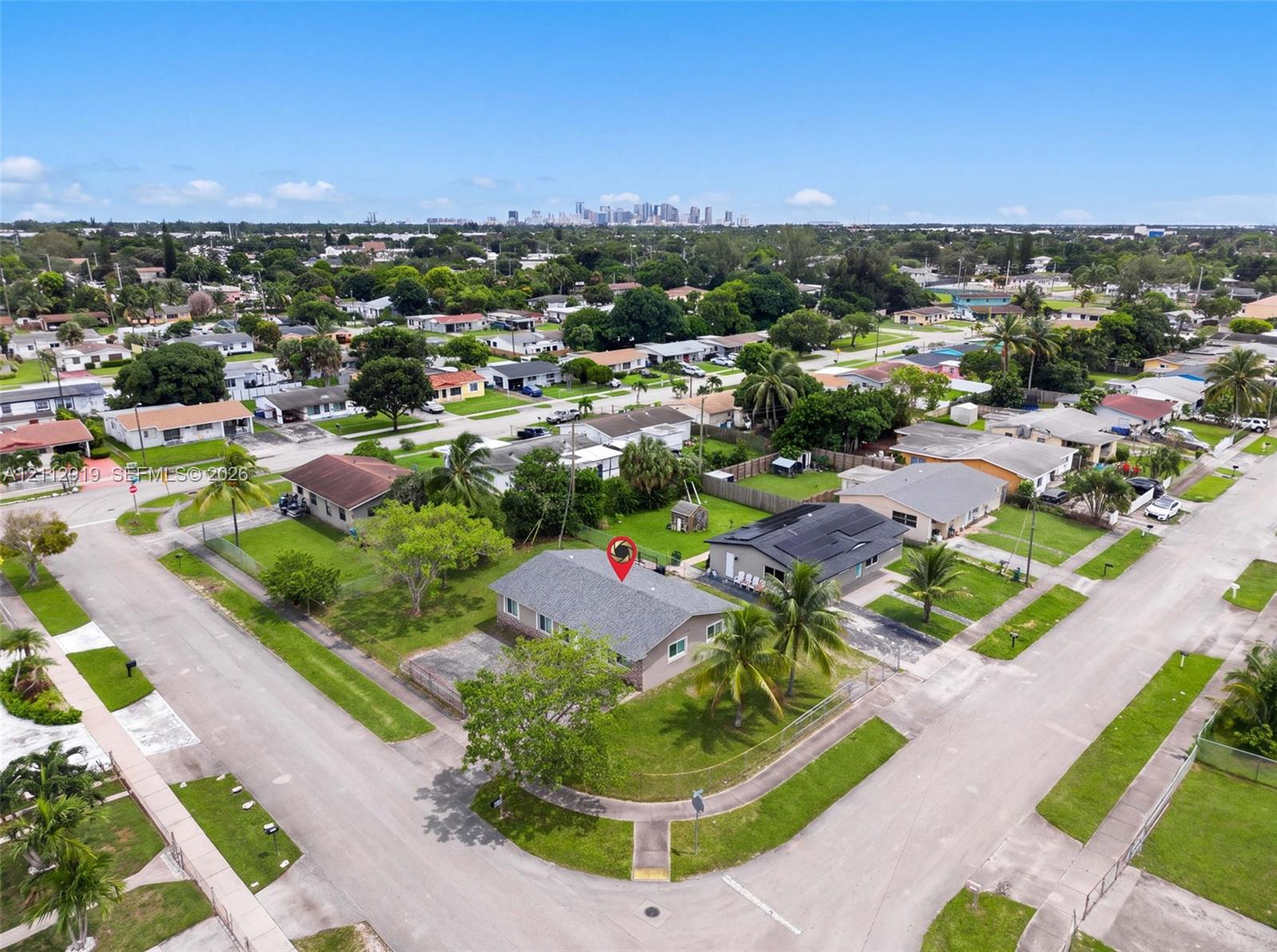 Corner lot property featuring a low-slope roof, concrete driveway, and mature landscaping