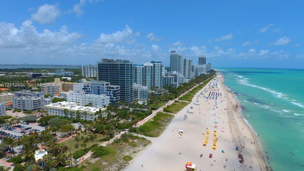 Aerial perspective showcasing immediate proximity to the Atlantic Ocean coastline, expansive sandy beaches, and high-density urban infrastructure