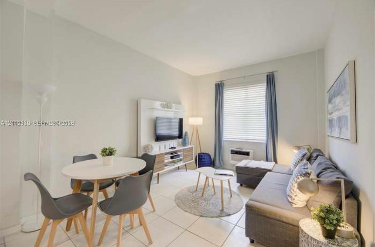Neutral-toned interior featuring large-format tile flooring and a built-in media console