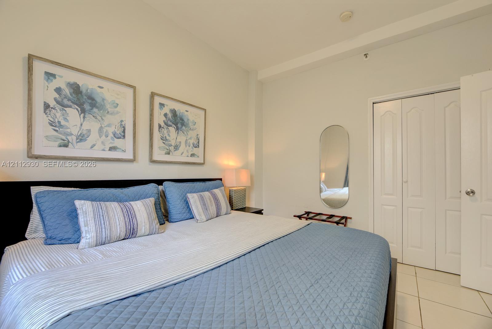 Neutral-toned walls, tile flooring, and a multi-panel closet door