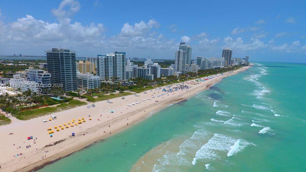 Coastal aerial perspective featuring direct oceanfront access, sandy shoreline, and high-rise structures