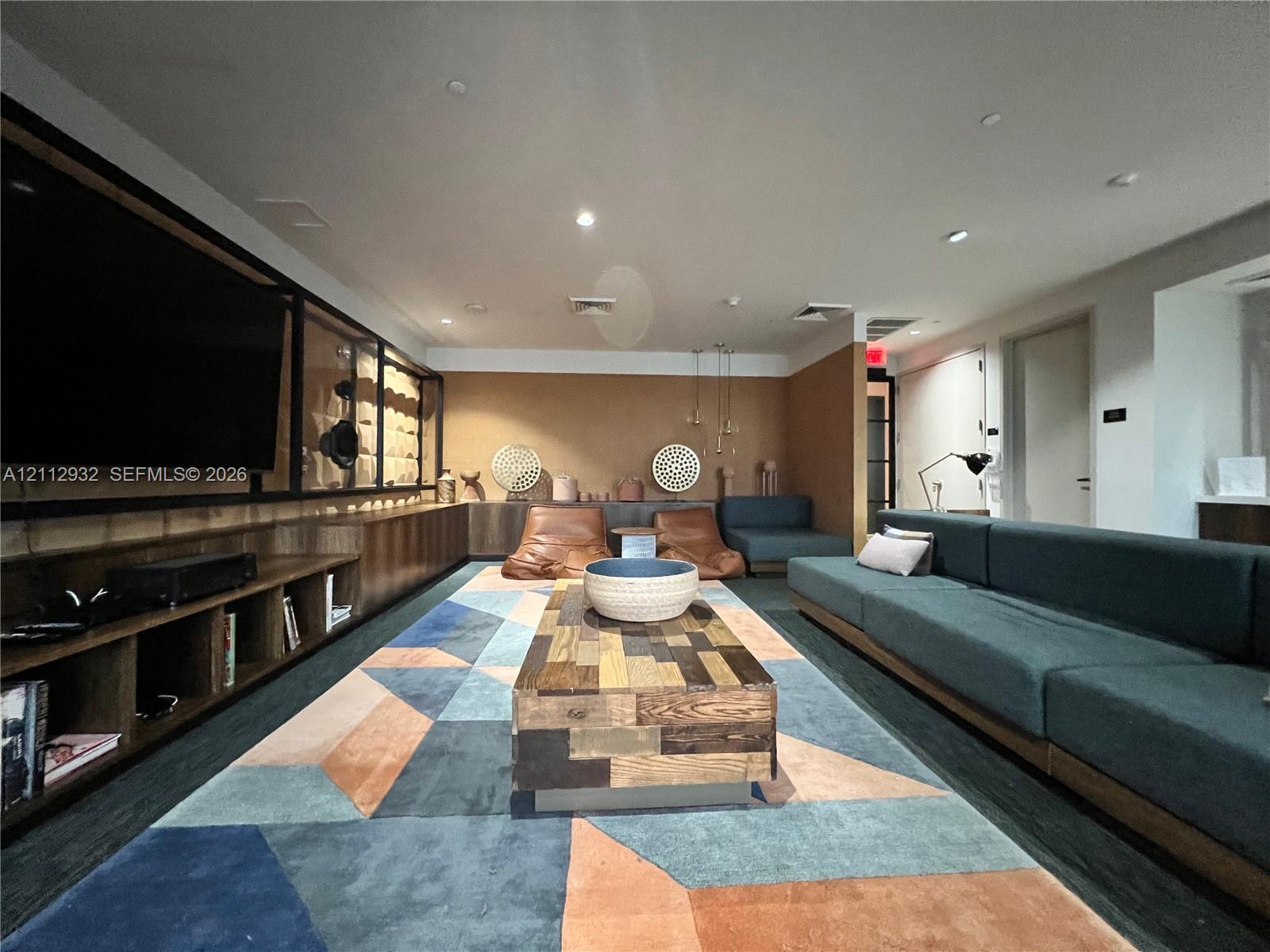 Custom wood cabinetry featuring integrated open shelving, recessed ceiling lighting, and solid surface paneling