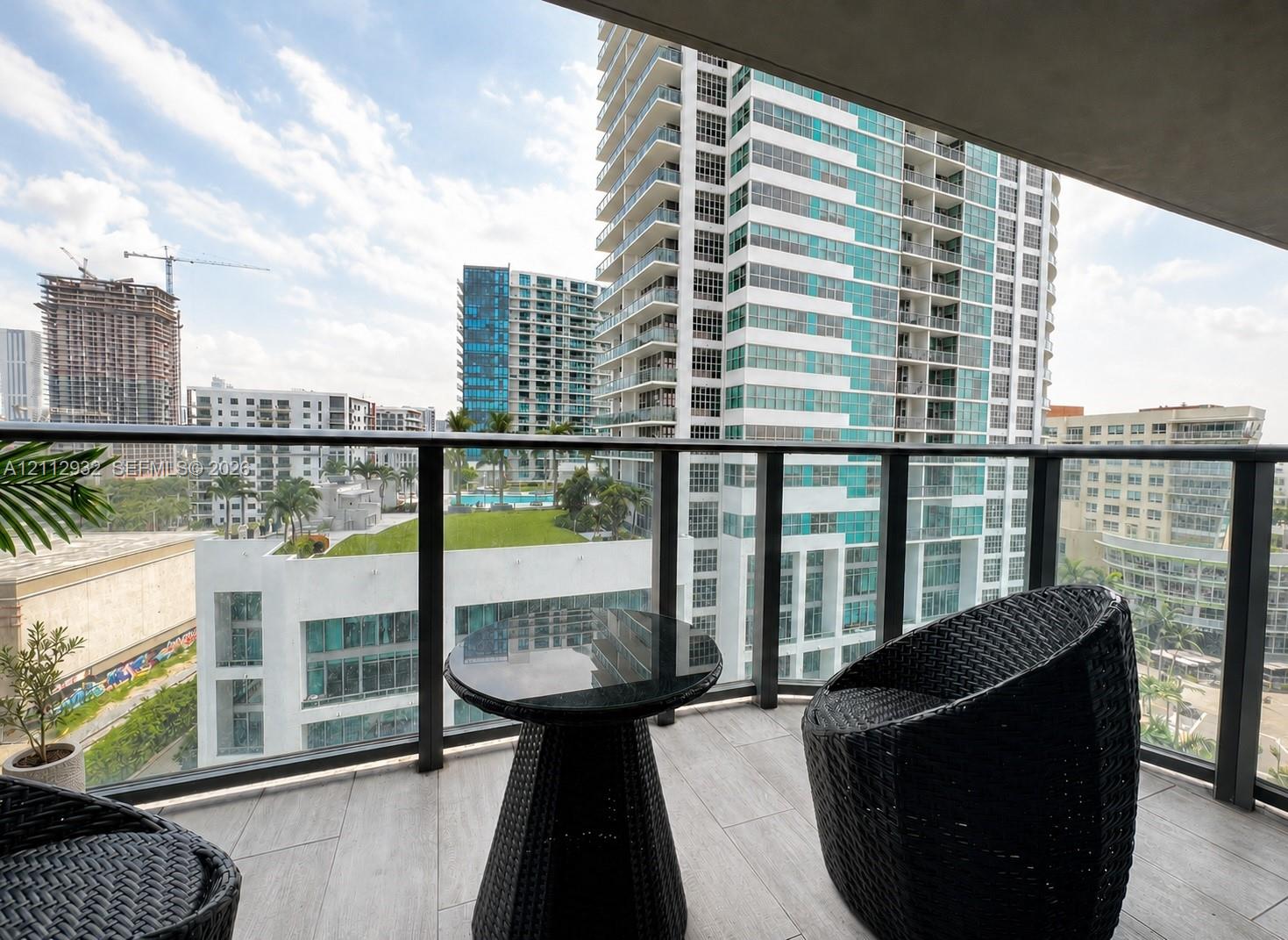 Private balcony featuring tile flooring and a glass-paneled railing