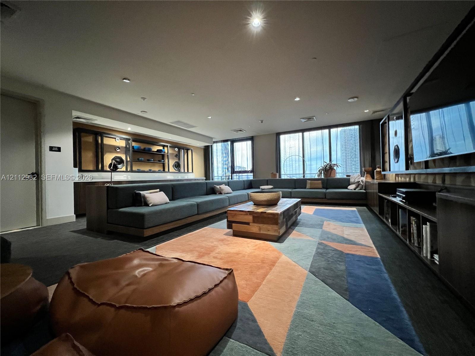 Built-in cabinetry with integrated shelving, recessed lighting, and expansive floor-to-ceiling windows