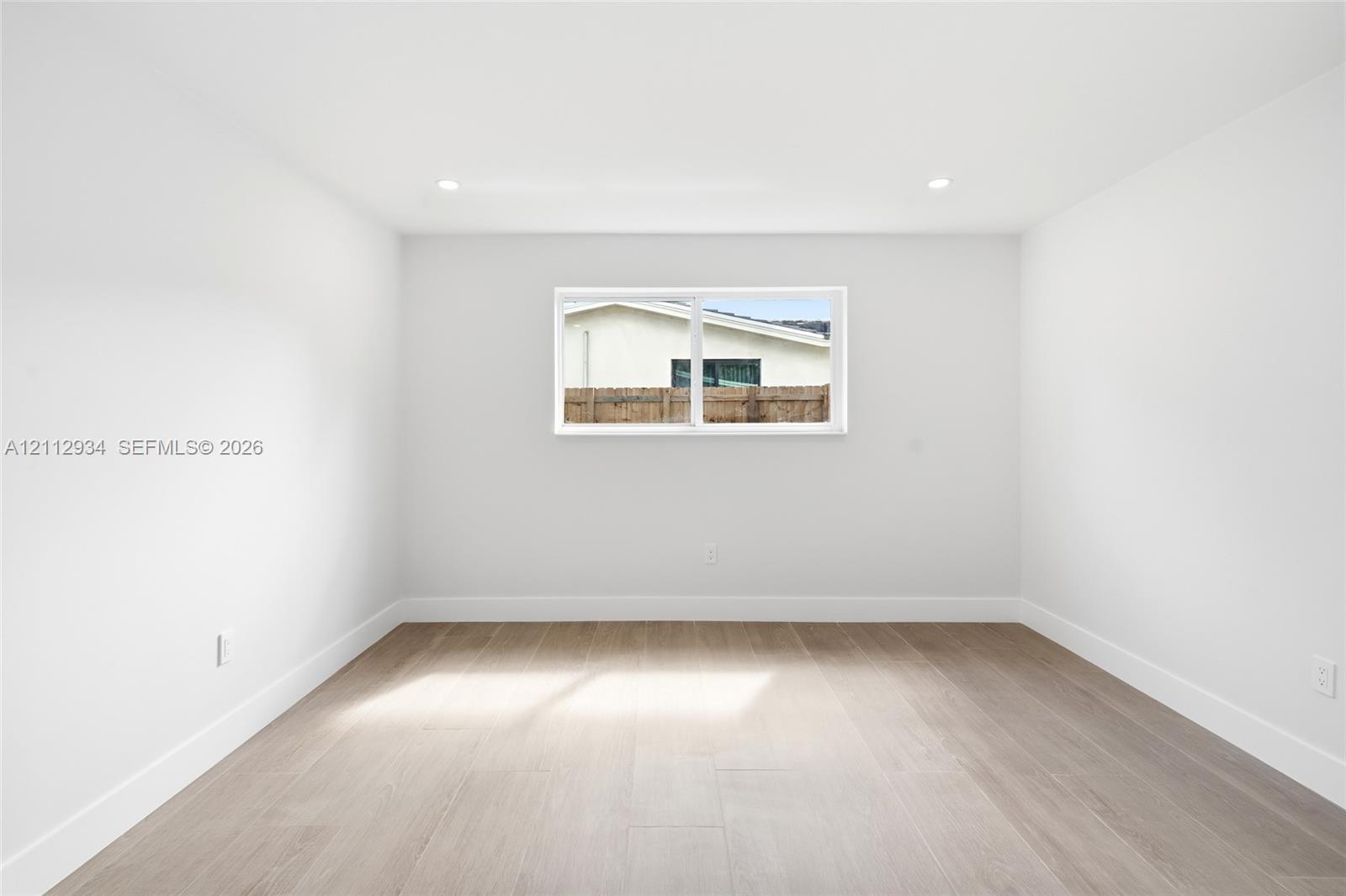 Neutral interior featuring wood-finish flooring, recessed lighting, and a horizontal sliding window
