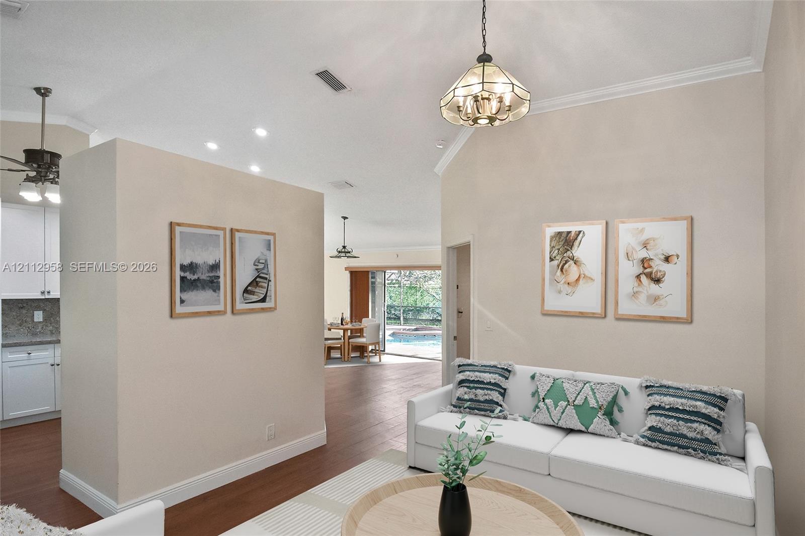 Vaulted ceilings, wood-finish flooring, decorative stained-glass pendant lighting, and sliding glass doors