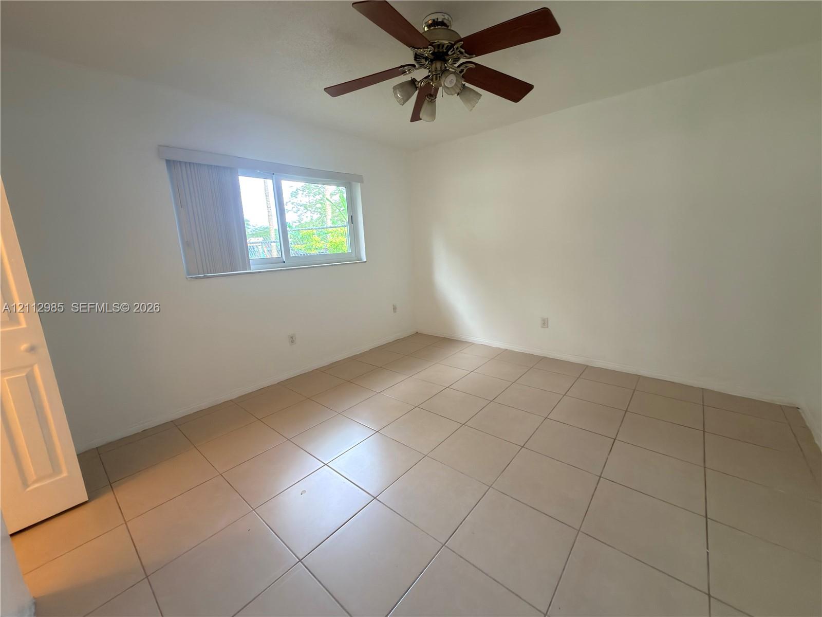 Neutral-toned ceramic tile flooring, ceiling fan with integrated lighting, and horizontal sliding window