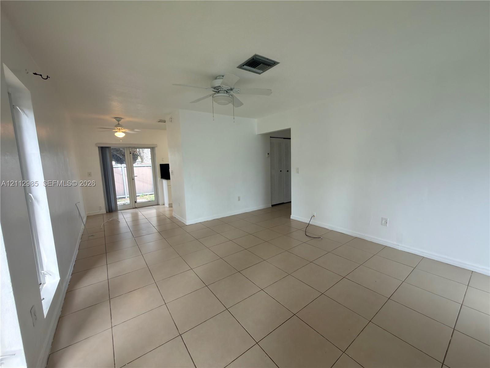 Large-format tile flooring, dual ceiling fans, and sliding glass exterior doors Large-format tile flooring, dual ceiling fans, and sliding glass exterior doors