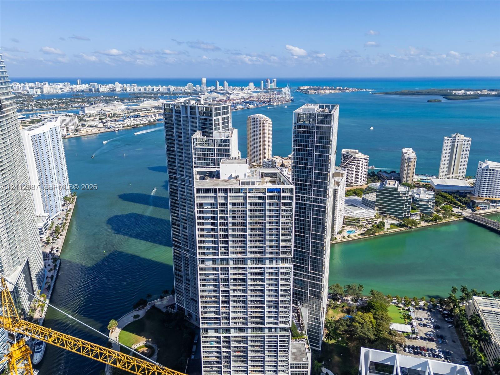 High-rise residential tower featuring floor-to-ceiling glass windows, exterior balconies, and a prominent waterfront location