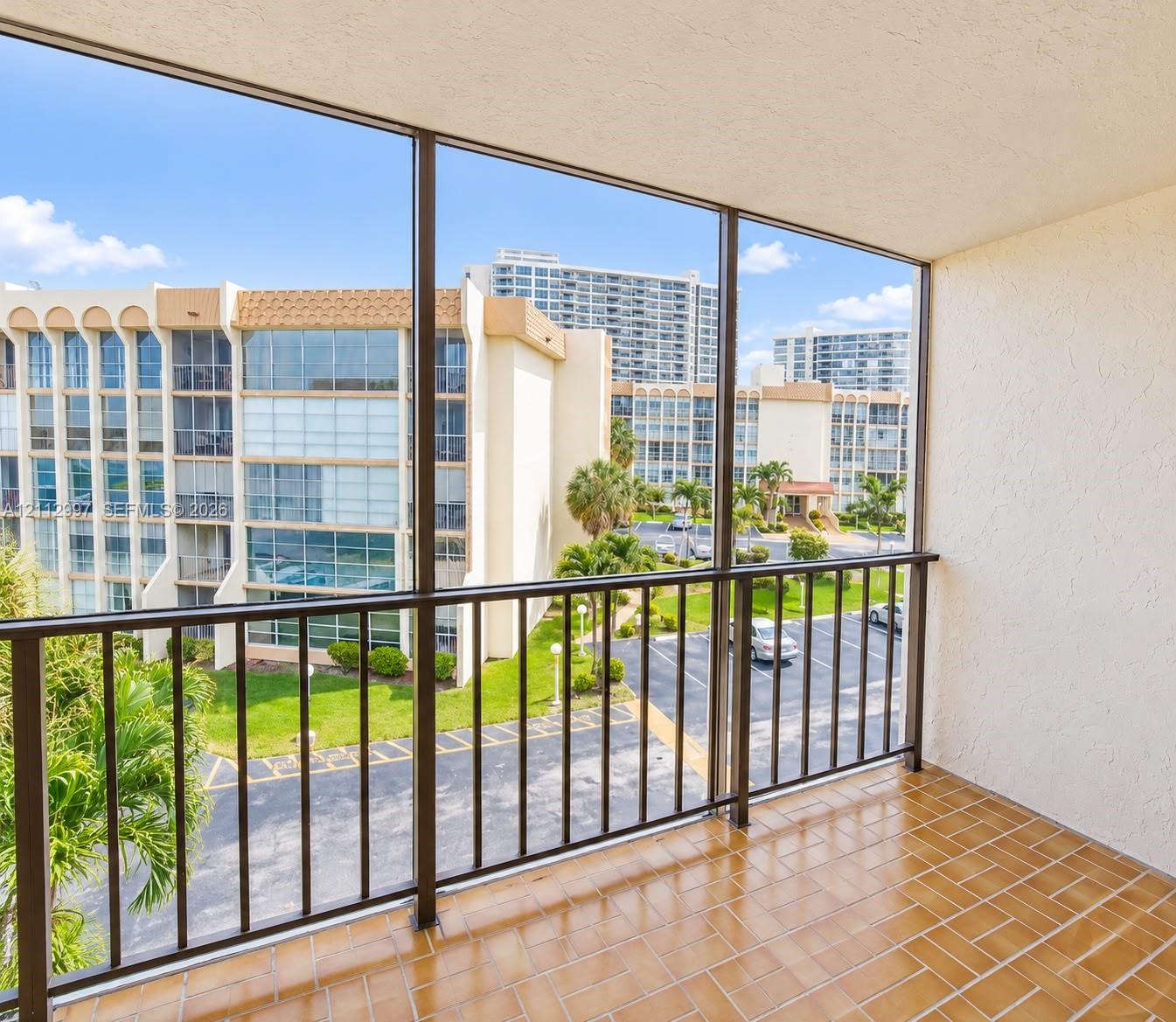Screened-in balcony featuring tile flooring and metal railings Screened-in balcony featuring tile flooring and metal railings