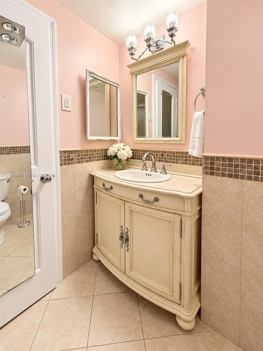 Vanity featuring a stone countertop, an integrated oval basin, and antique-style cabinetry with decorative hardware