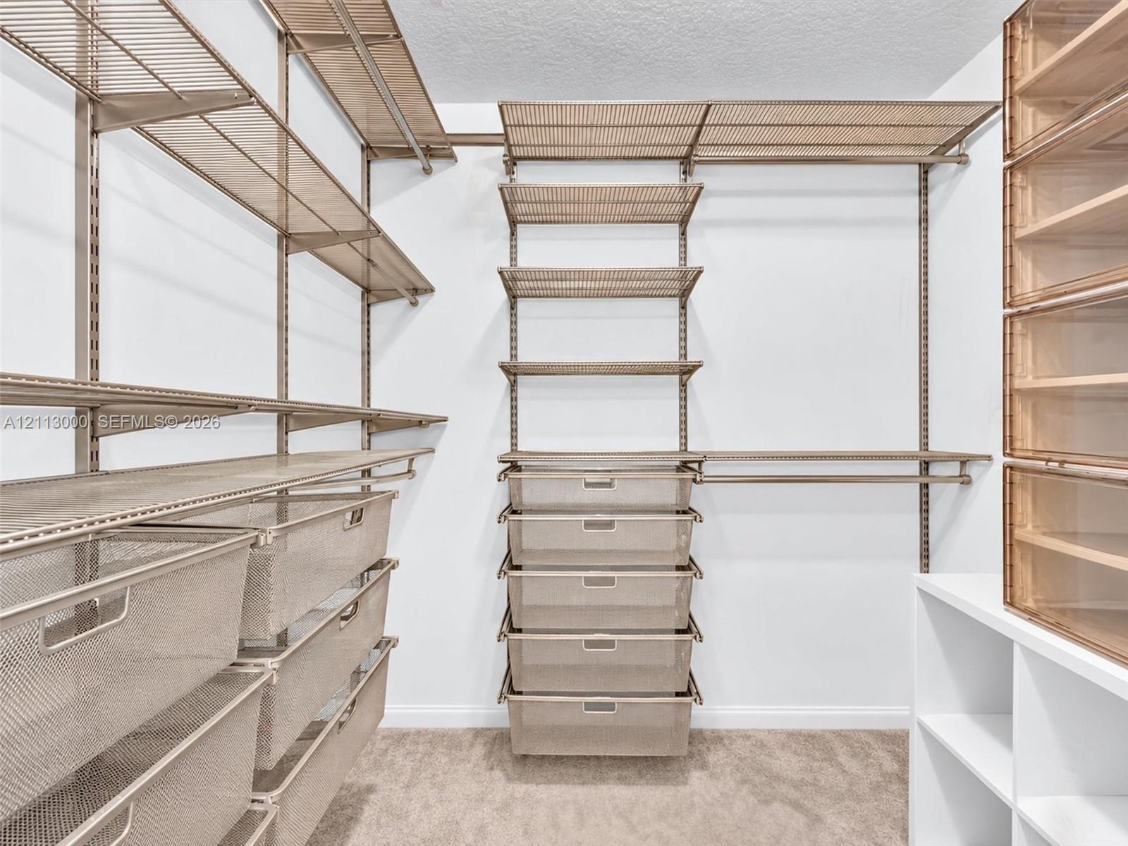 Customizable closet organization system featuring modular metal shelving, pull-out wire drawers, integrated hanging rods, and built-in tiered cabinetry