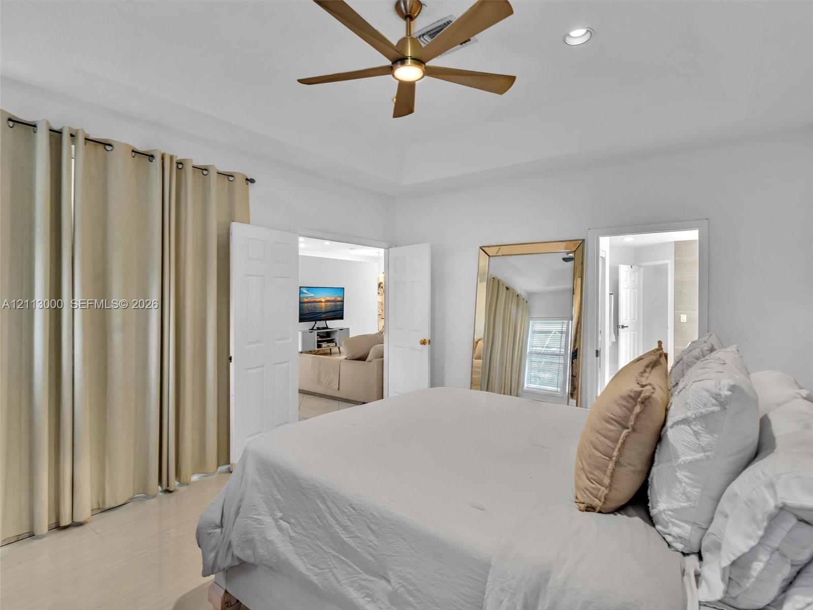 Tray ceiling featuring a brushed-brass multi-blade ceiling fan and recessed lighting