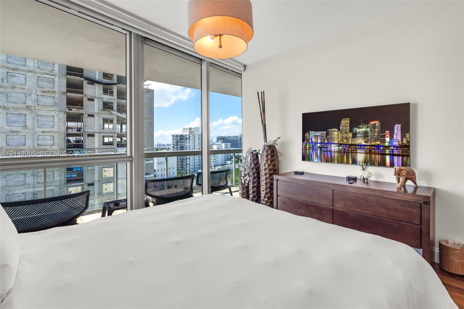 Floor-to-ceiling glass windows, recessed ceiling lighting, and private balcony access