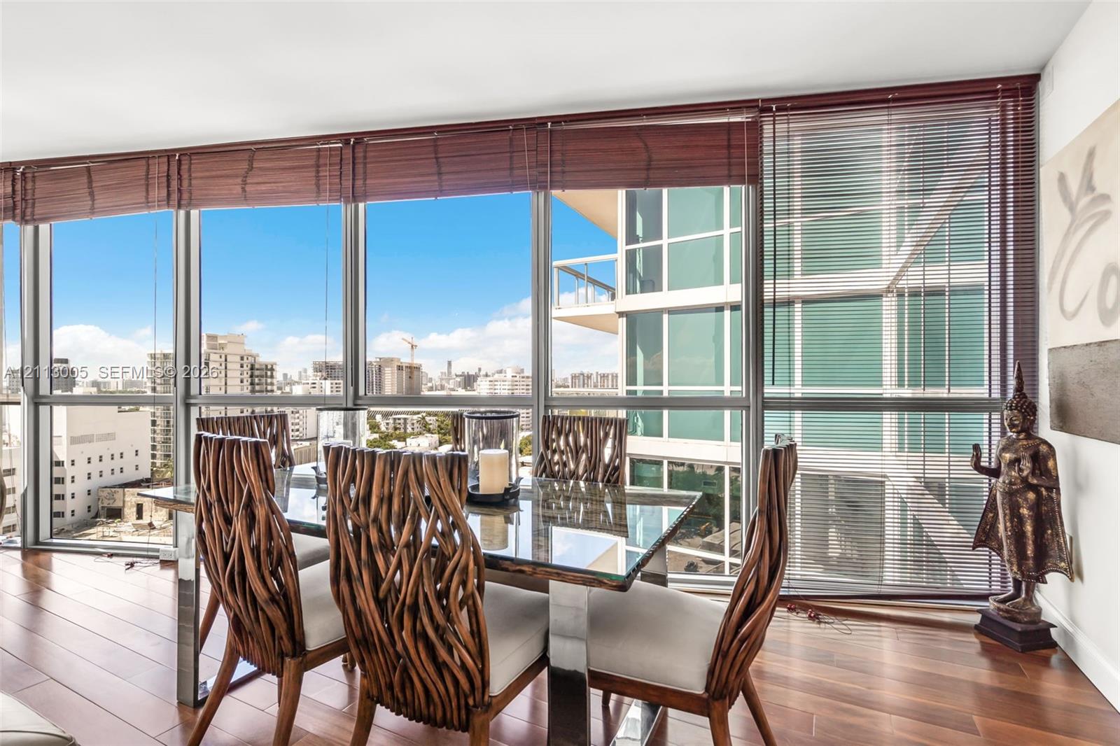 Floor-to-ceiling windows, wood-finish flooring, and horizontal slat window treatments