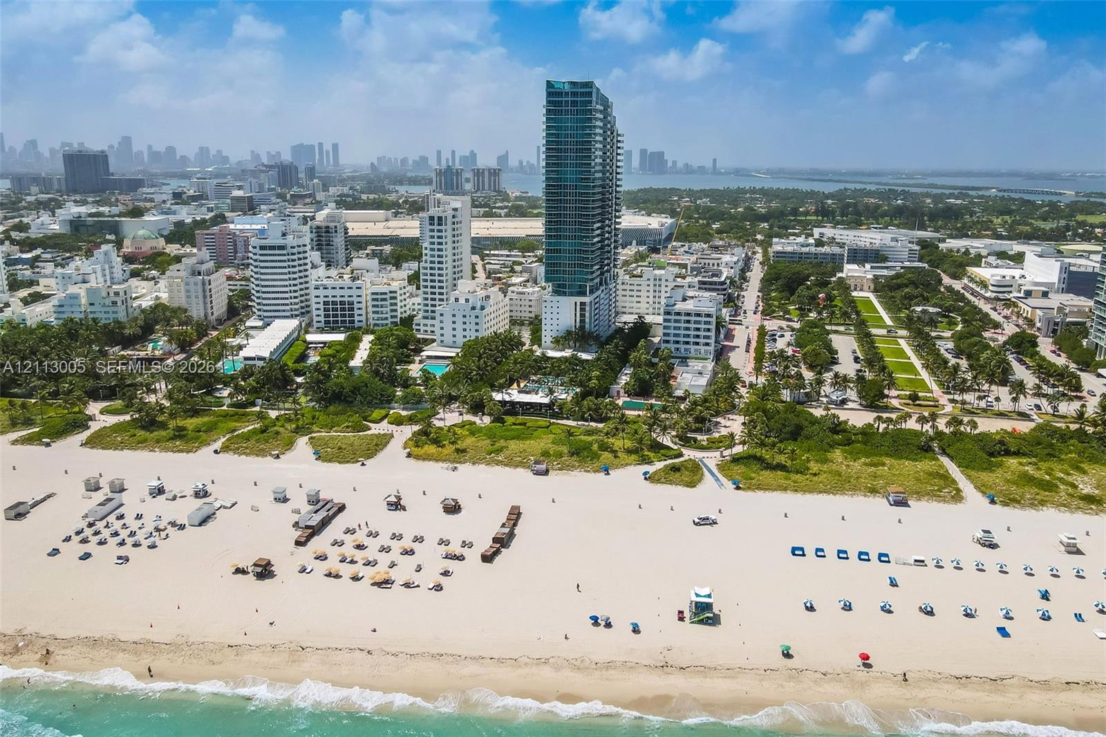 High-rise residential tower featuring a glass facade, oceanfront proximity, and expansive coastal shoreline
