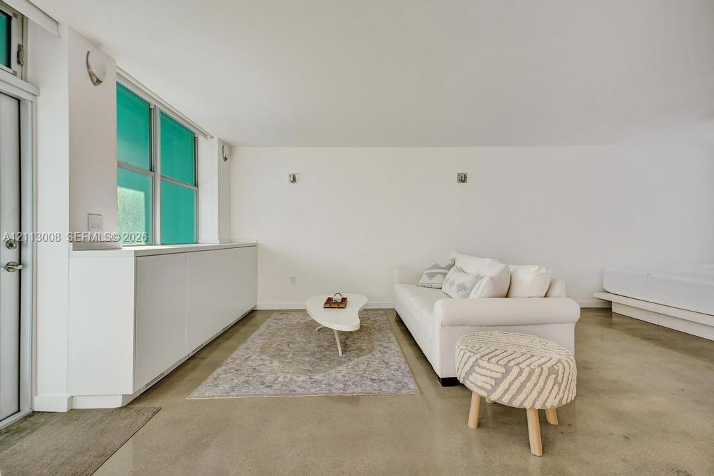 Polished concrete flooring, built-in floor-to-ceiling cabinetry, and wall-mounted light fixtures