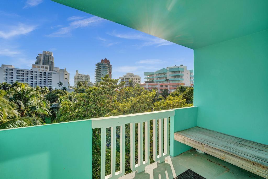 Covered balcony featuring a built-in bench, concrete flooring, and a decorative slatted railing