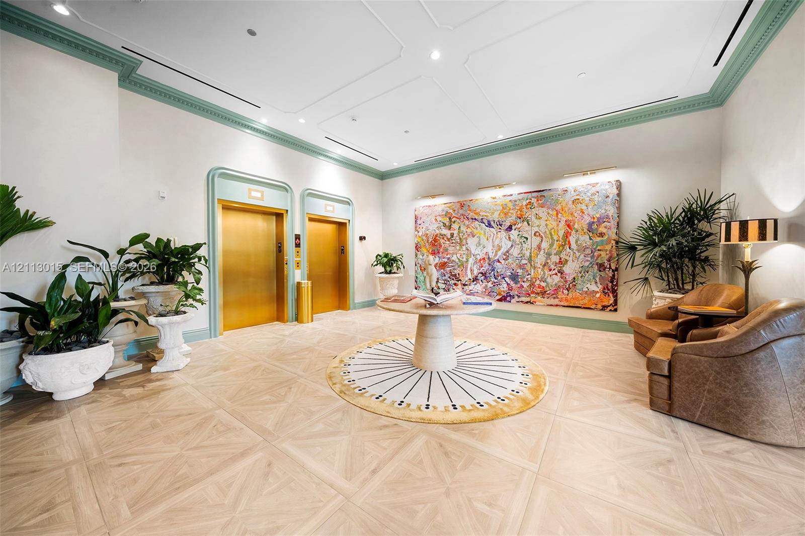 Elevator lobby featuring geometric wood-finish flooring, custom decorative molding, dual brass-finish elevator doors, and recessed ceiling lighting