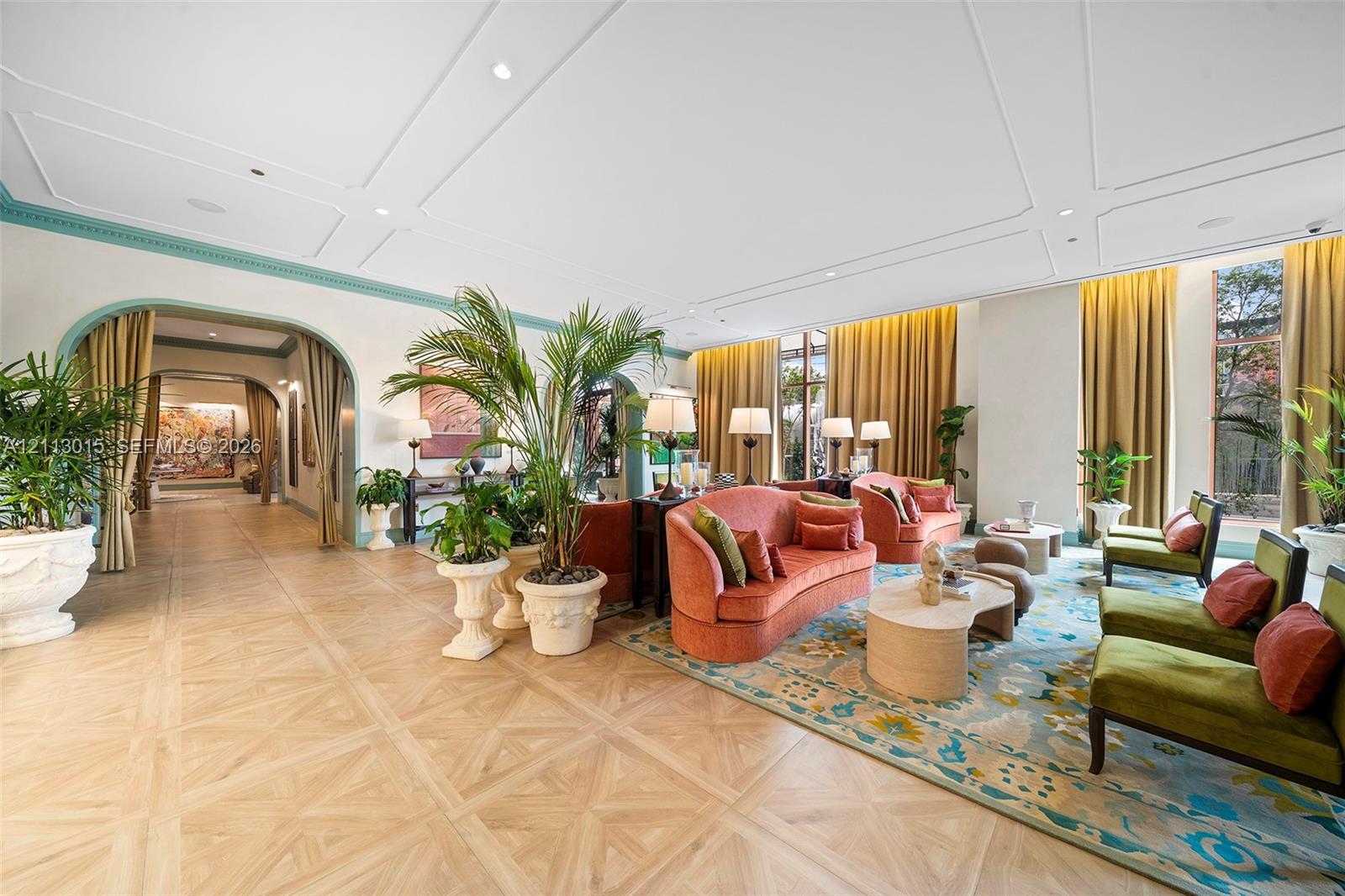 Expansive room featuring intricate parquet wood flooring, decorative ceiling molding, arched entries with accent trim, and floor-to-ceiling windows