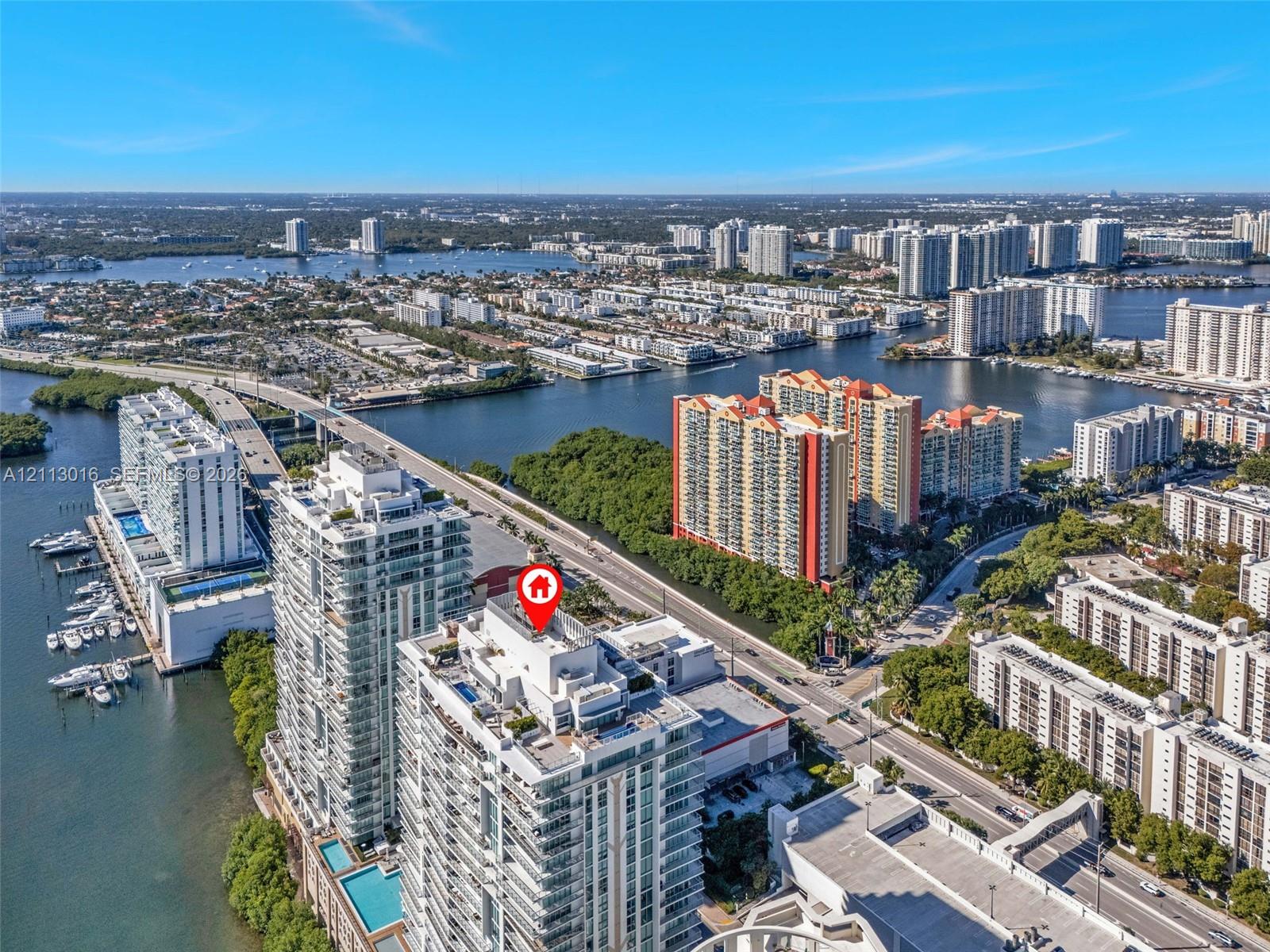Aerial perspective of high-rise building featuring water-front proximity and expansive maritime surroundings