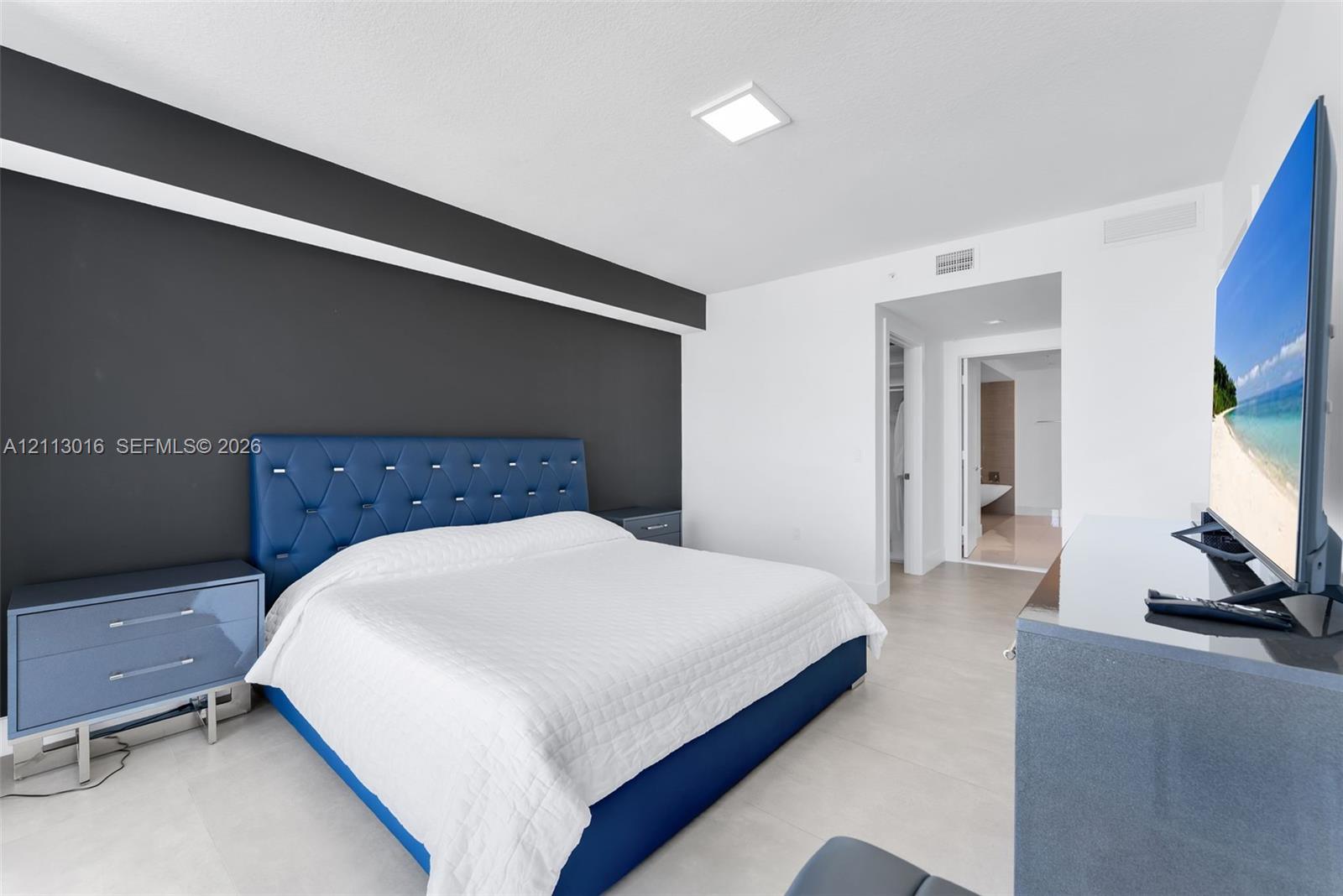 Interior space featuring a dark accent wall, recessed LED ceiling lighting, and large-format tile flooring