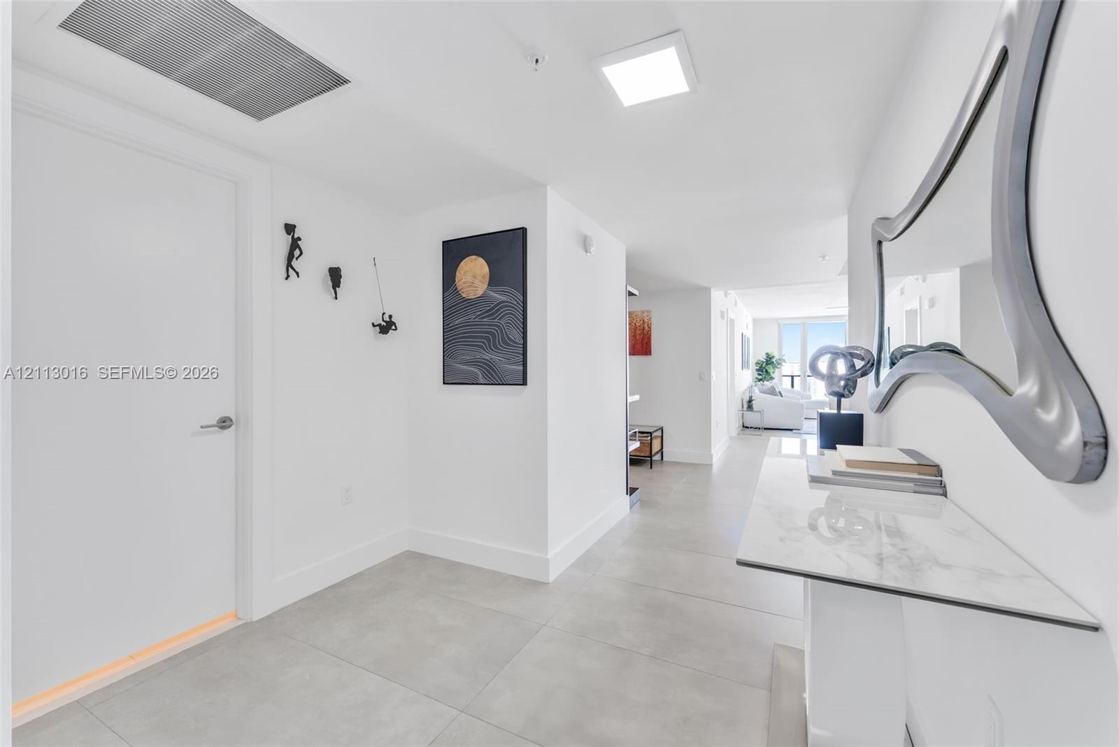 Entryway featuring large-format ceramic tile flooring, recessed square ceiling lighting, and a neutral color palette Entryway featuring large-format ceramic tile flooring, recessed square ceiling lighting, and a neutral color palette