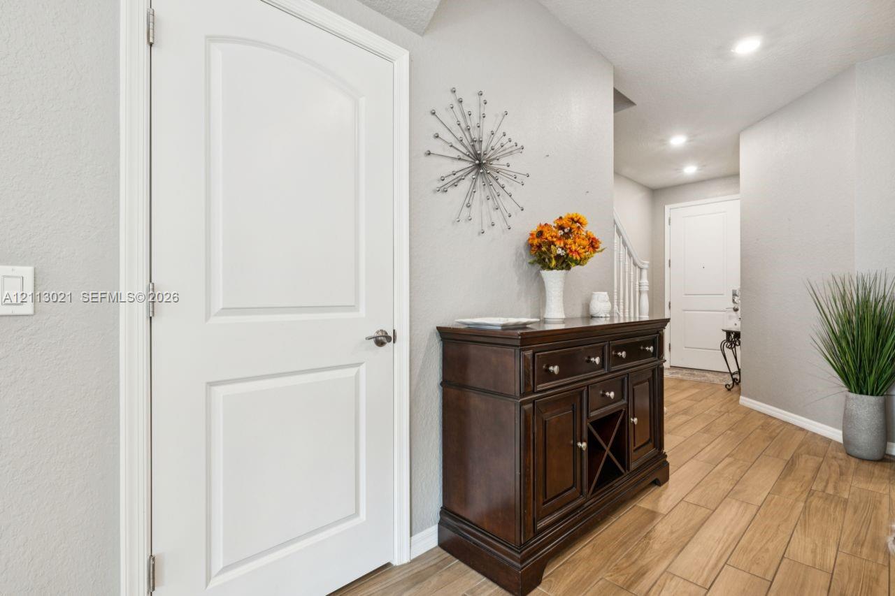 Wood-finish flooring, recessed lighting, and white panel doors Wood-finish flooring, recessed lighting, and white panel doors