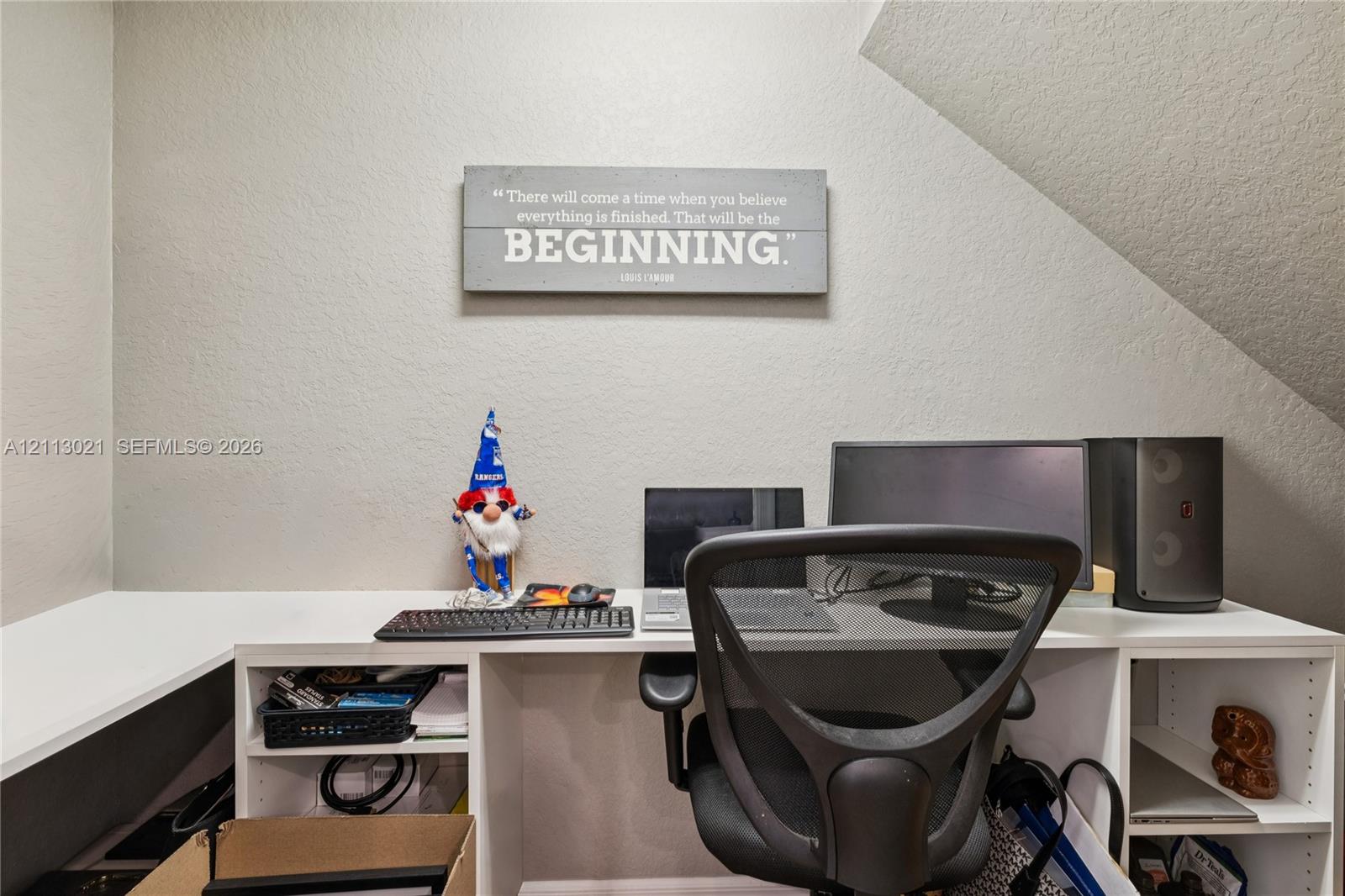 Built-in white desk featuring open shelving and a solid-surface desktop