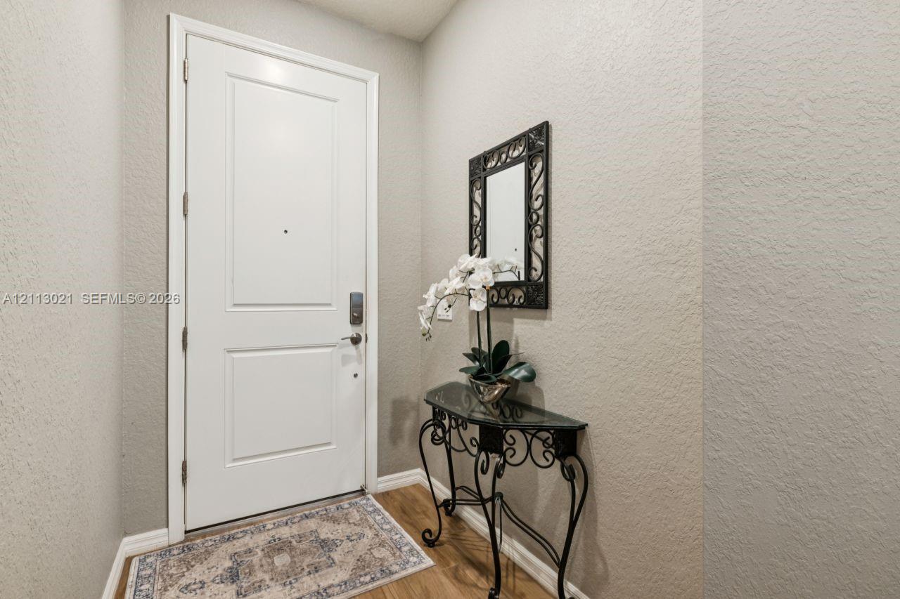 Solid core paneled door with brushed metallic hardware and wood-finish flooring Solid core paneled door with brushed metallic hardware and wood-finish flooring
