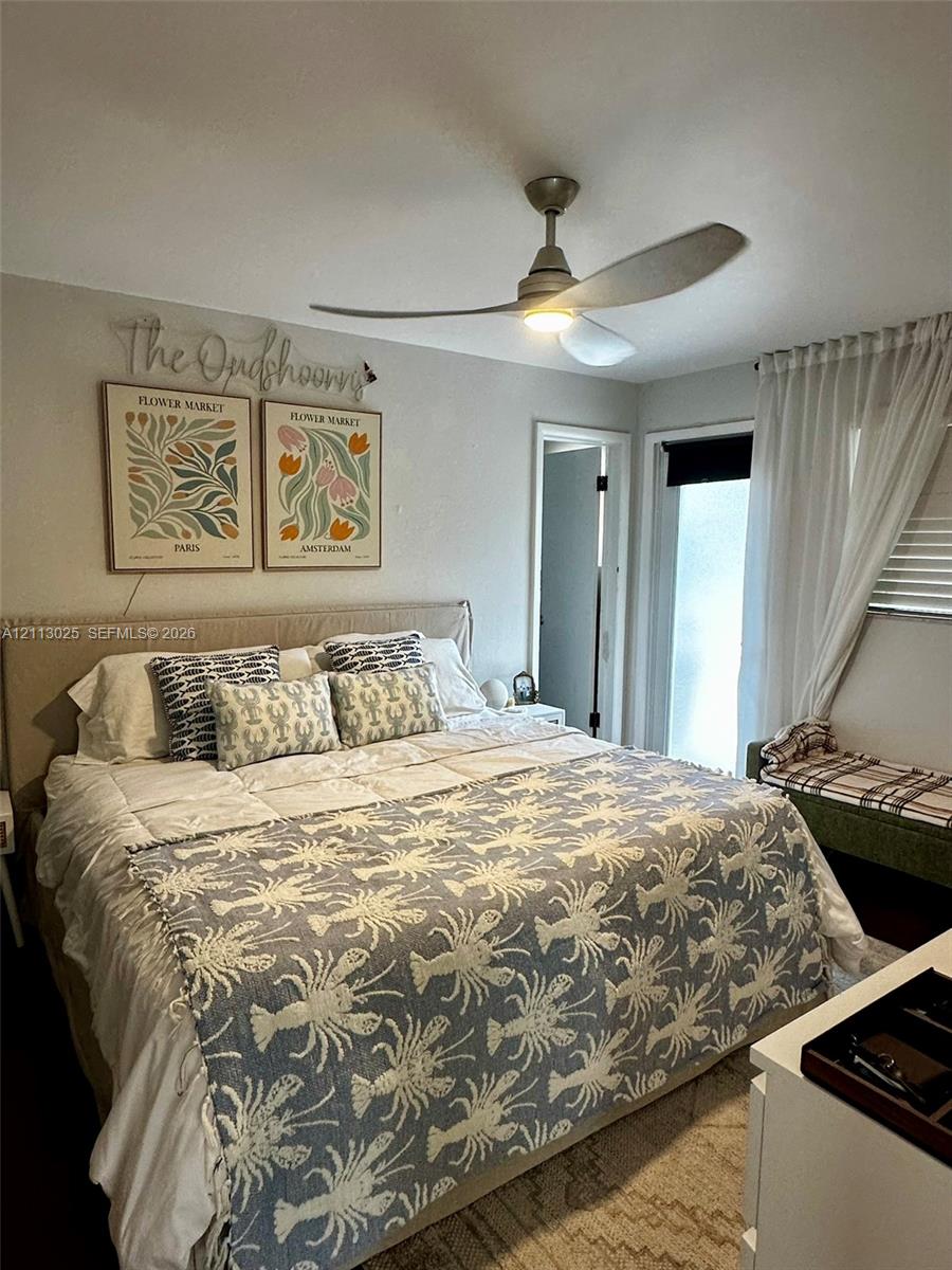 Neutral-toned interior featuring a modern three-blade ceiling fan with integrated lighting, door with sidelight window, and window equipped with horizontal blinds