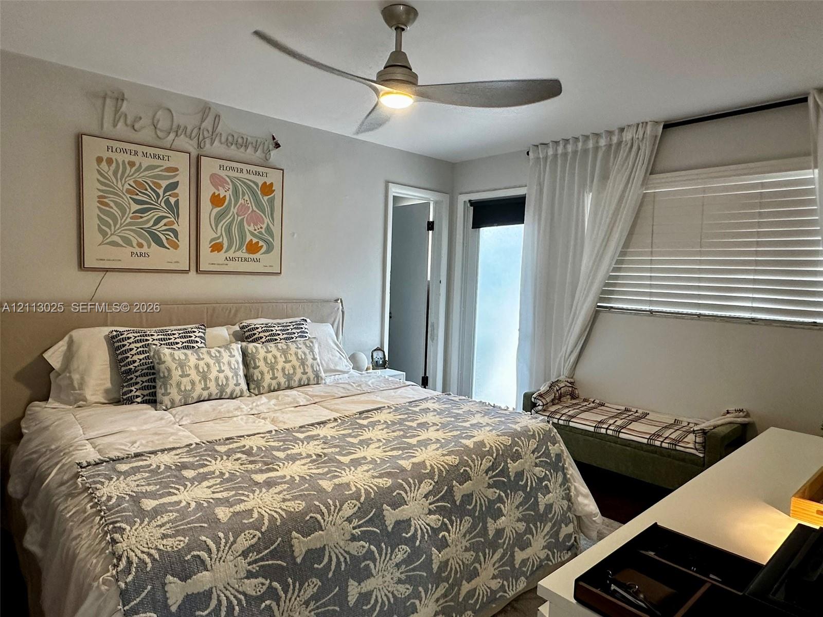 Modern three-blade ceiling fan with integrated lighting, neutral wall palette, and horizontal window blinds