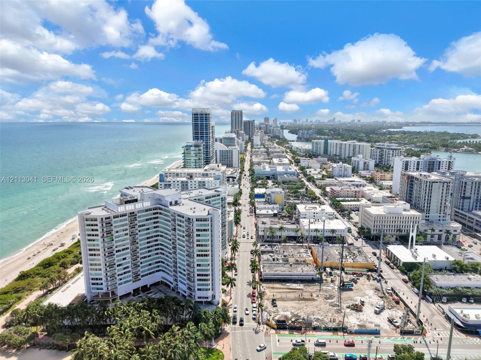 Aerial perspective of coastal high-rise development featuring direct oceanfront exposure, expansive shoreline, and proximity to metropolitan infrastructure