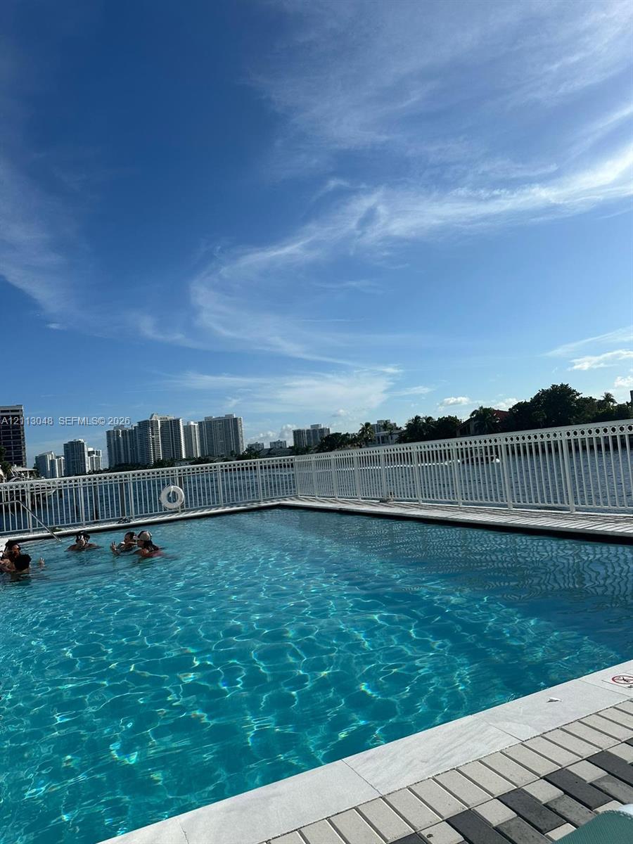 Waterfront swimming pool with tiled coping and a perimeter safety fence