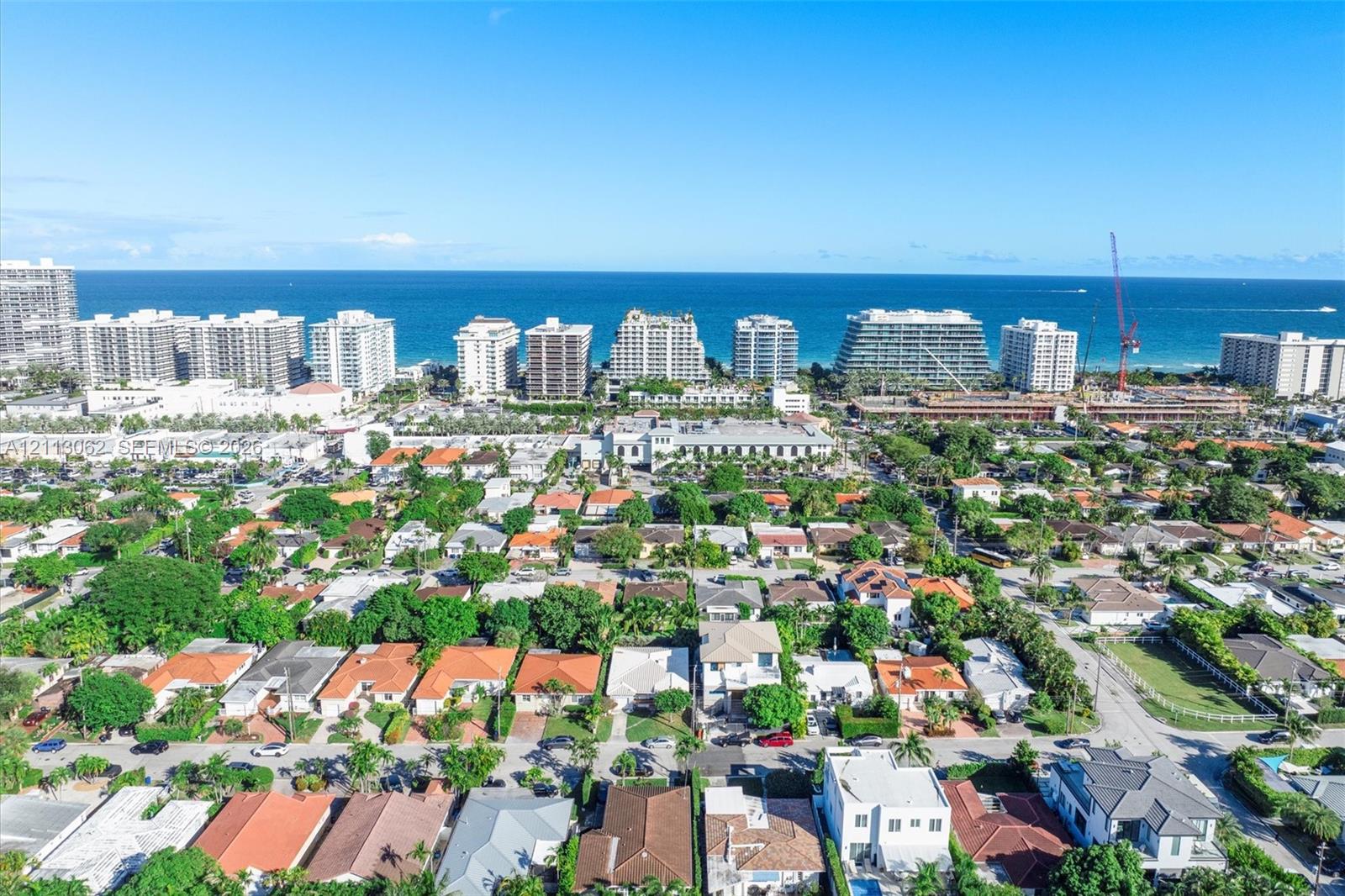 Aerial perspective featuring a coastal residential landscape, expansive ocean horizon, and diverse architectural structures