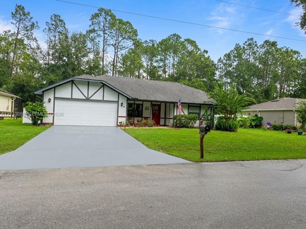 Single-story exterior featuring Tudor-style detailing, an attached two-car garage, concrete driveway, and landscaped front yard Single-story exterior featuring Tudor-style detailing, an attached two-car garage, concrete driveway, and landscaped front yard
