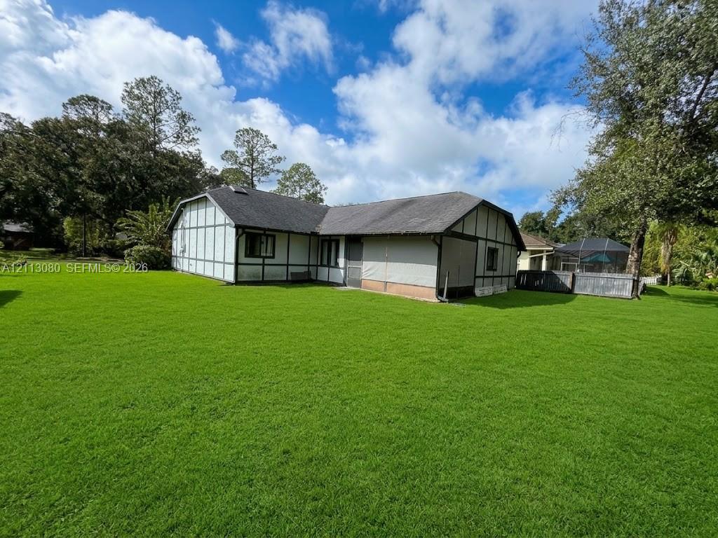 Tudor-style exterior featuring half-timbered detailing, a gabled roofline, and an expansive lawn