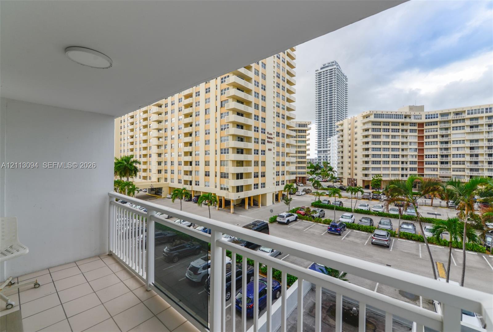 Covered balcony with white metal railings and tiled flooring